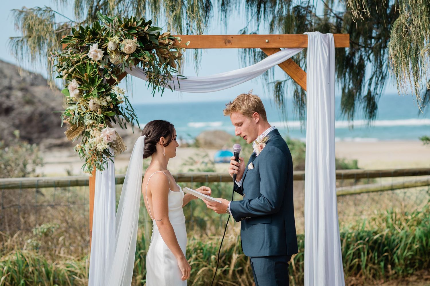 Beachside wedding ceremony under draped white fabric and willow trees.Miami Burleigh heads beach wedding