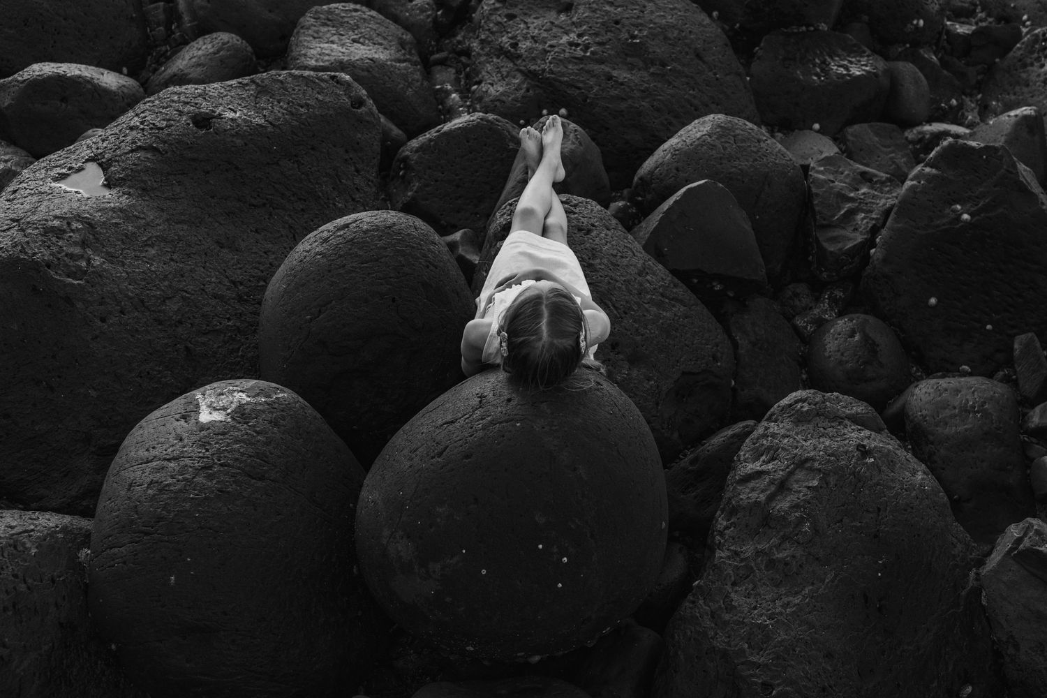 Dark volcanic rocks line a rugged coastline at sunset. Fingal head family photos -  New South Wales Gold Coast candid family photographer.