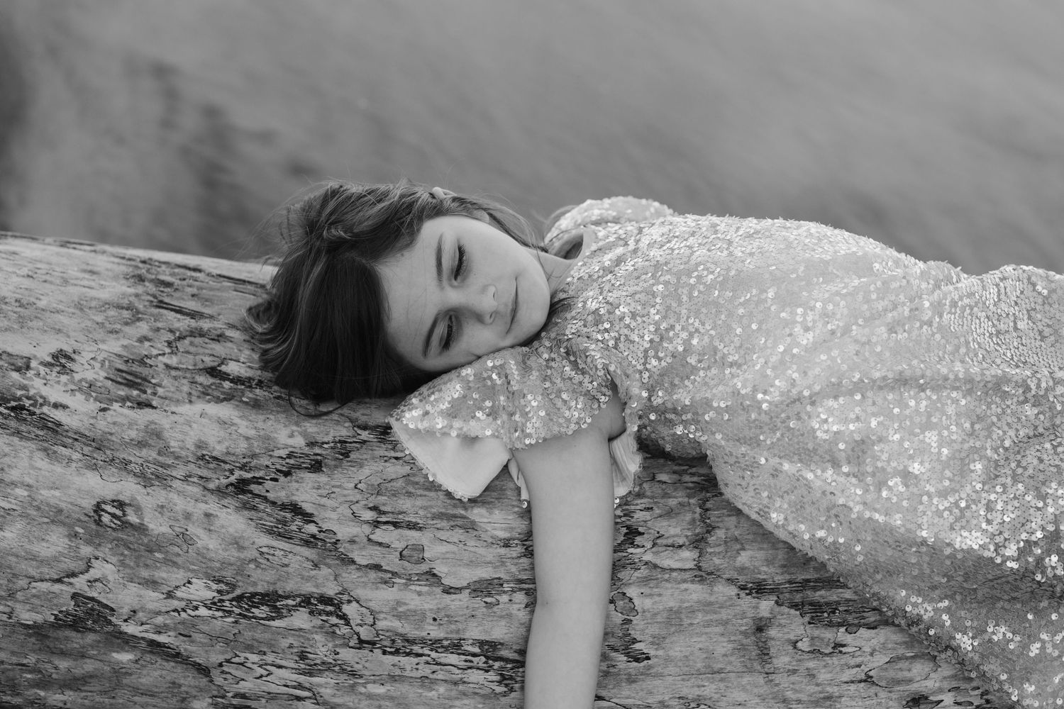 Sparkling sequin dress contrasts against rocky beach landscape in artistic portrait.Family photography cabarita New South Wales