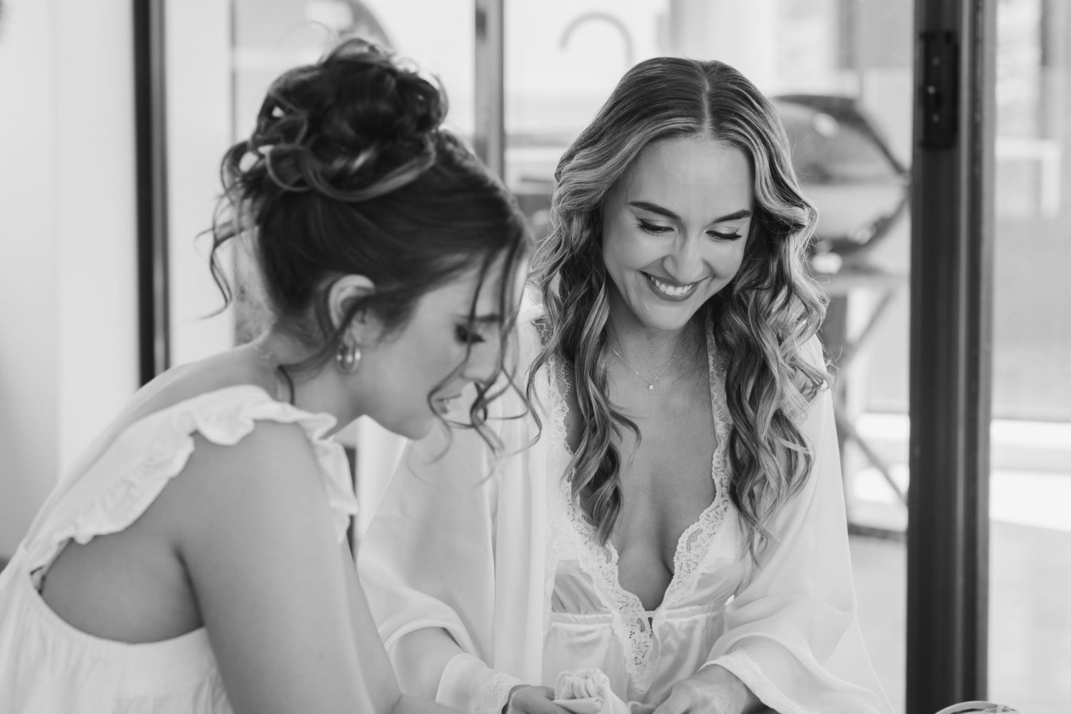 Wedding preparation scene with white robes and natural window light.