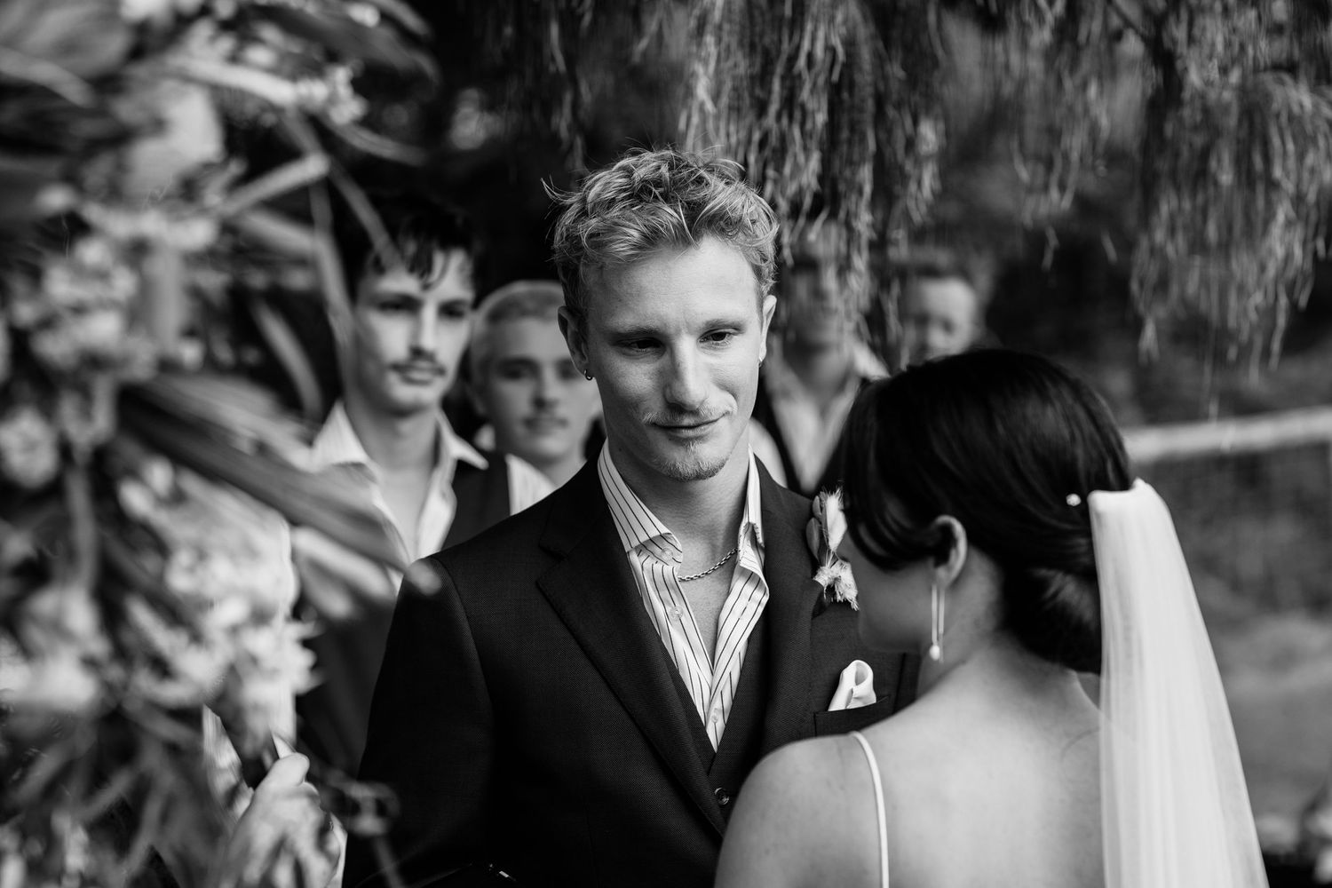 Black and white photo of wedding ceremony under willow trees.