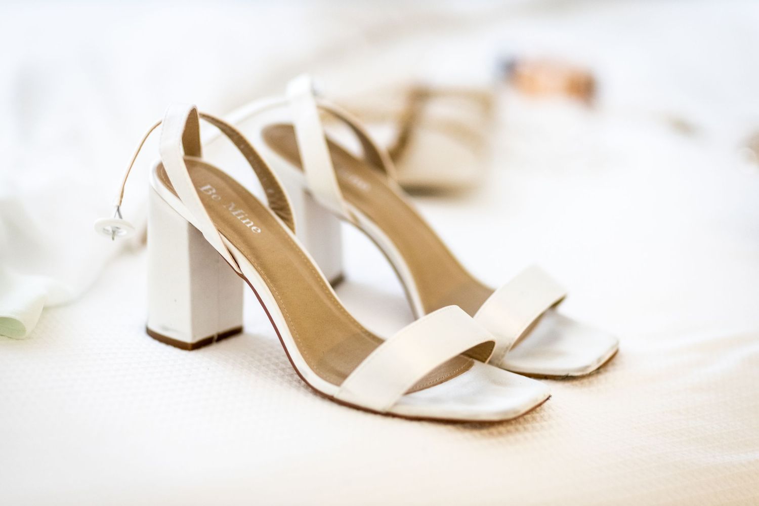 Elegant white bridal heels arranged on a soft white surface in natural light. Surfers Paradise Golf Club wedding.