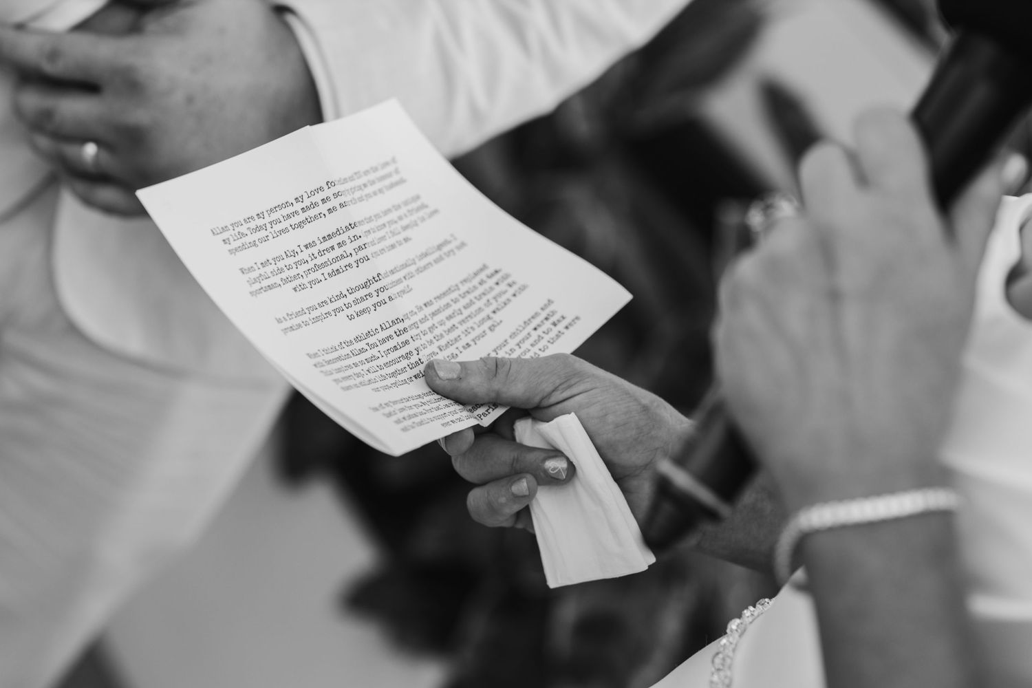 Wedding guests reading ceremony programs during an outdoor rooftop celebration.
