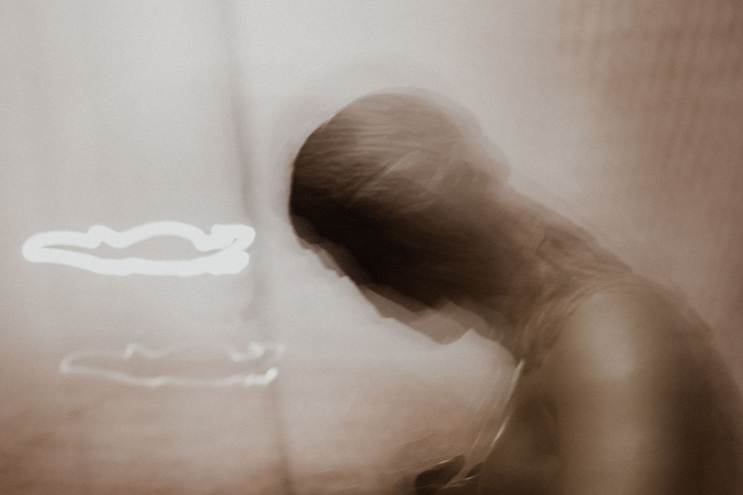 Ethereal silhouette figure in sepia tones with floating cloud-like shapes.