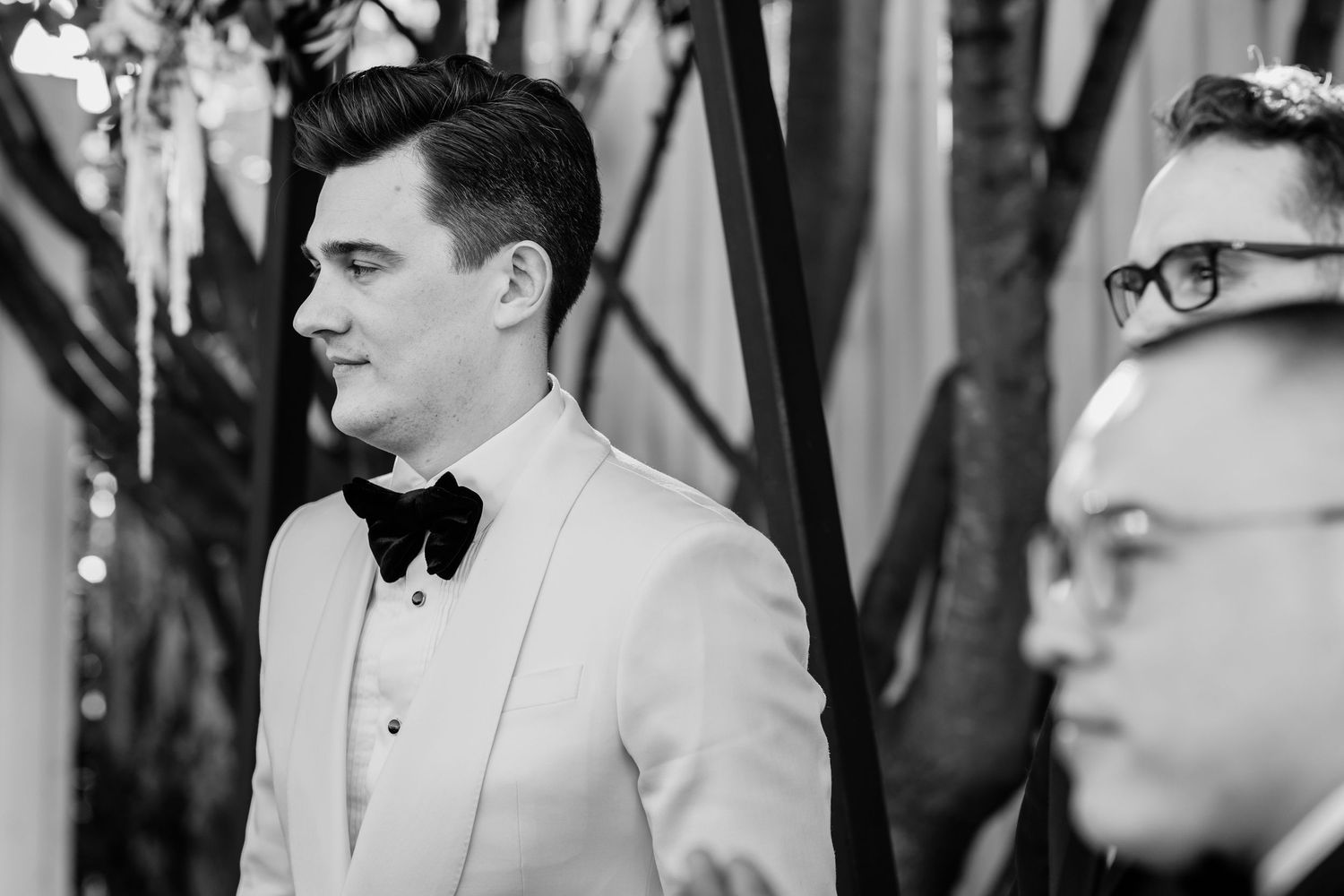 Wedding party members in formal black and white attire during ceremony.