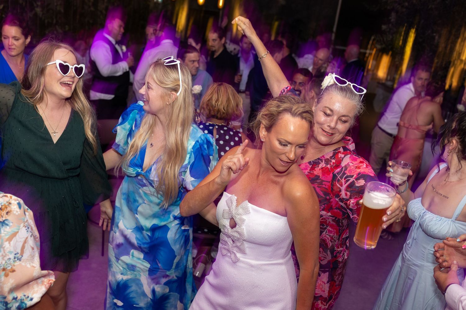 Colorful dance party scene with purple lighting and festive crowd enjoying the celebration.