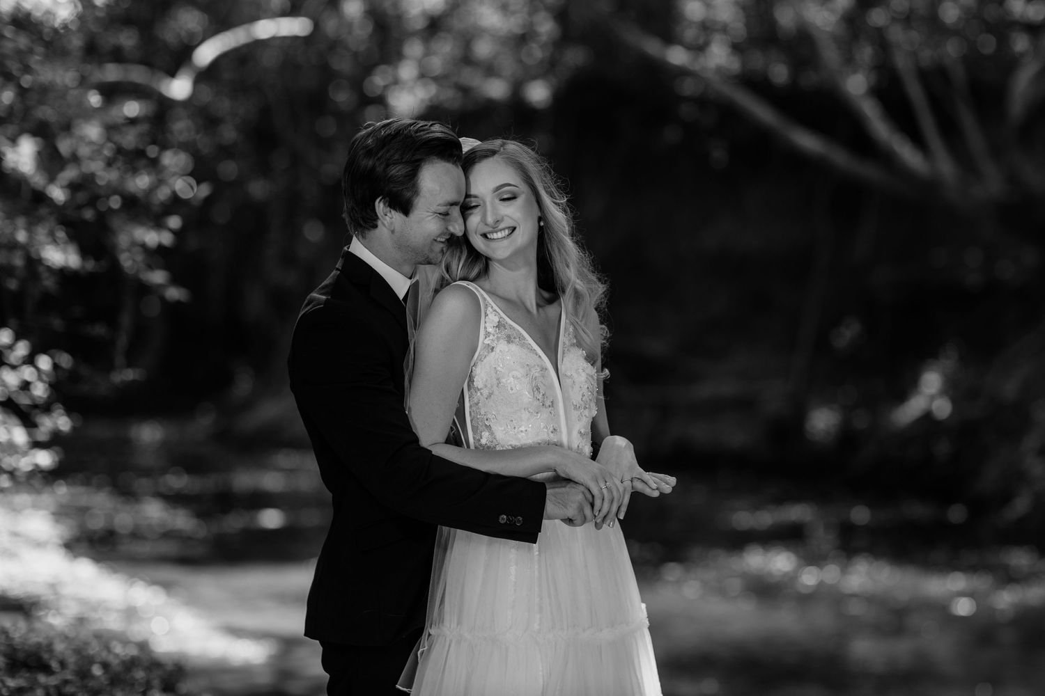 A romantic wedding couple shares an intimate moment in a wooded outdoor setting.Currumbin Valley wedding photography Gold Coast
