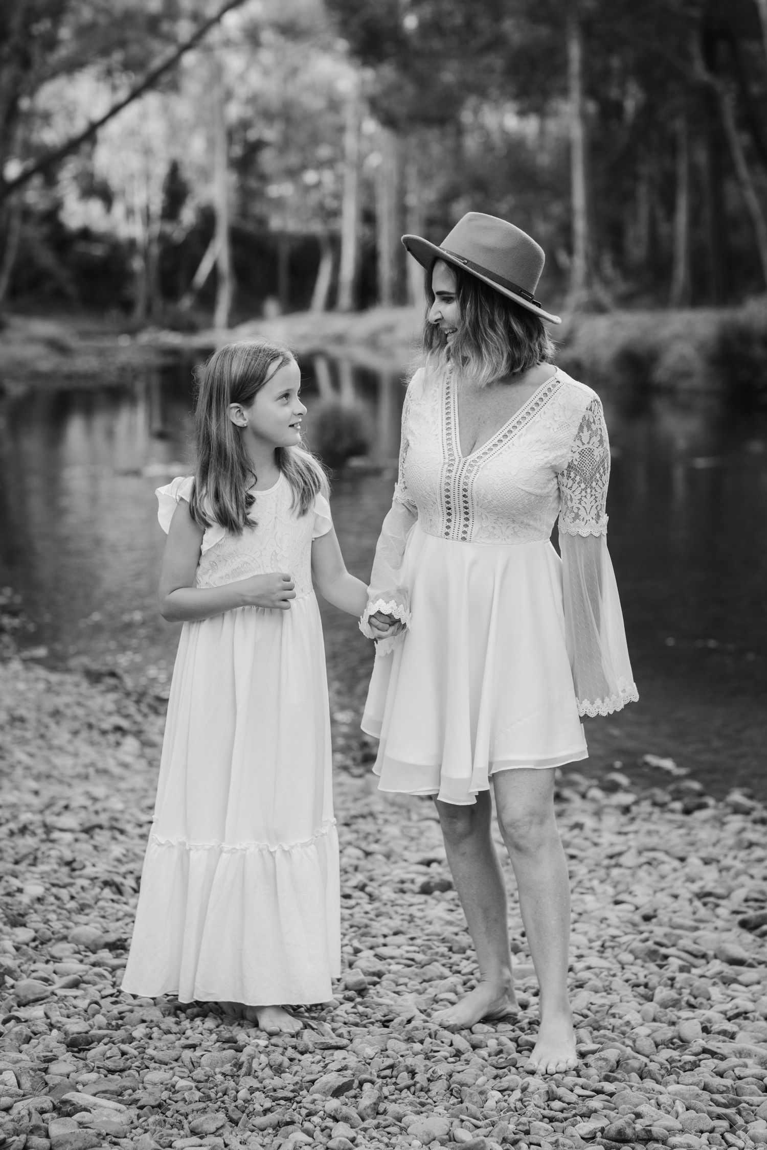 Black and white portrait of people in white dresses exploring a rocky shoreline.Tallebudgera family photography. Gold Coast