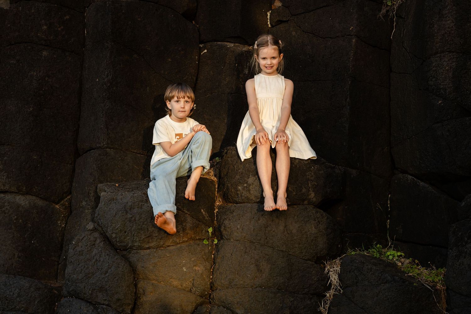 Two dancers perform on dark rocky terrain with dramatic lighting and shadows.Fingal head family photos -  New South Wales Gold Coast candid