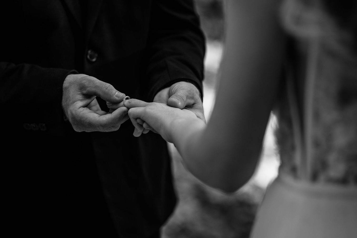 Black and white close-up of ring exchange during wedding ceremony.Currumbin Valley wedding photography Gold Coast