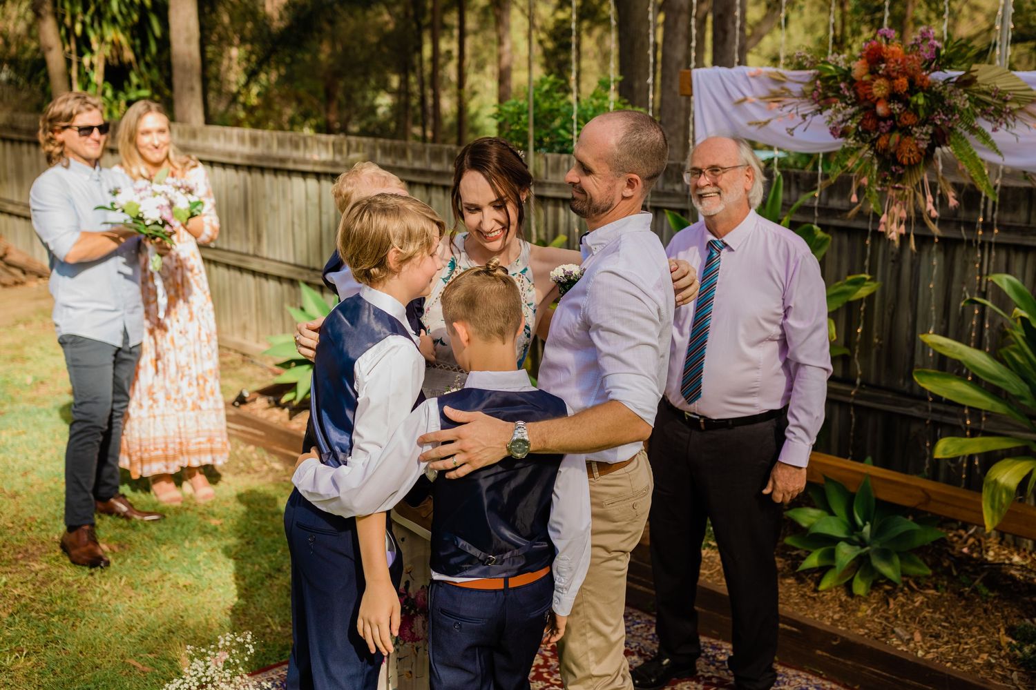 Family gathering in a backyard garden setting during a celebration.