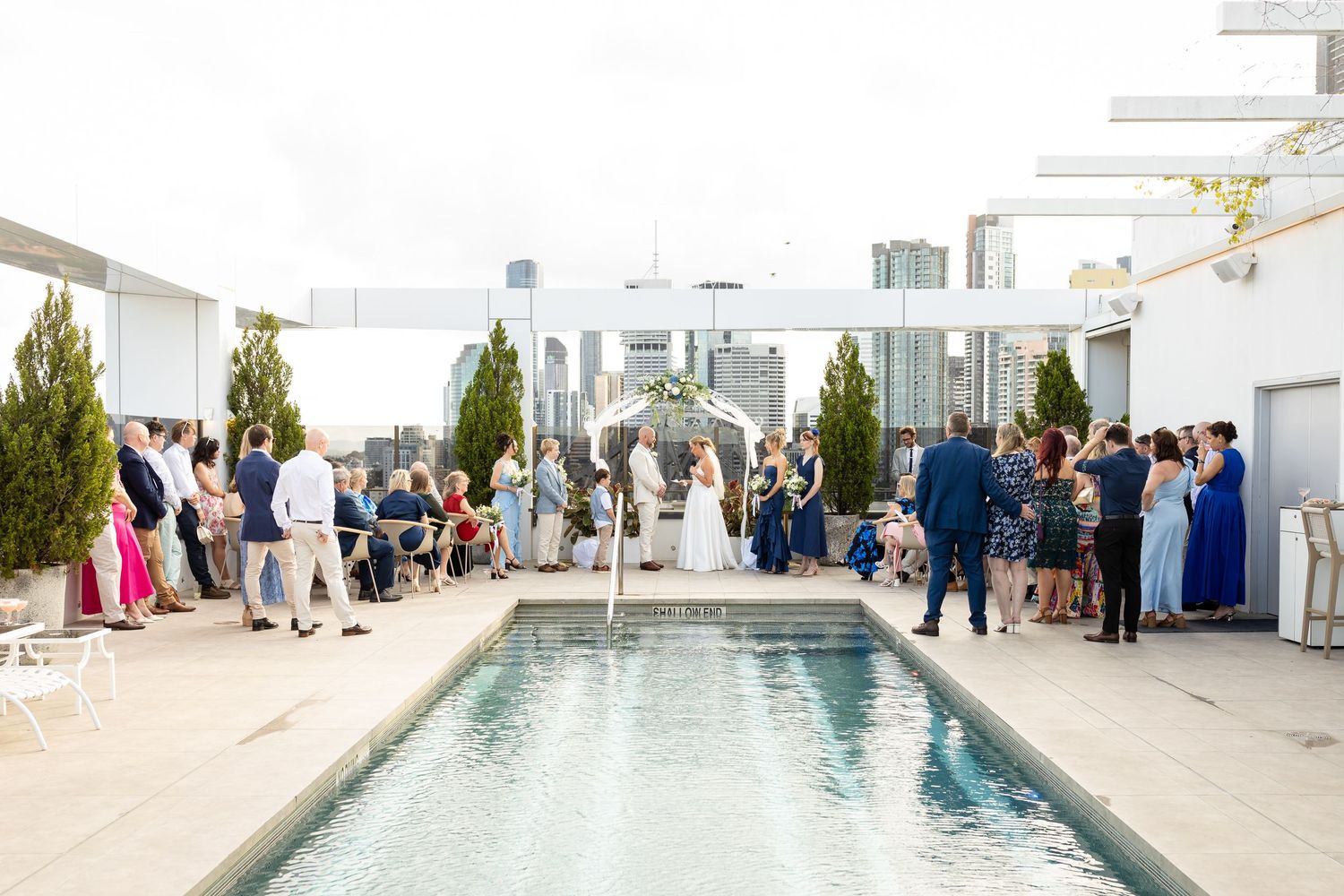 Modern rooftop wedding venue featuring a reflection pool and skyline views. Brisbane wedding venue.wedding ceremony at iris rooftop hotel in