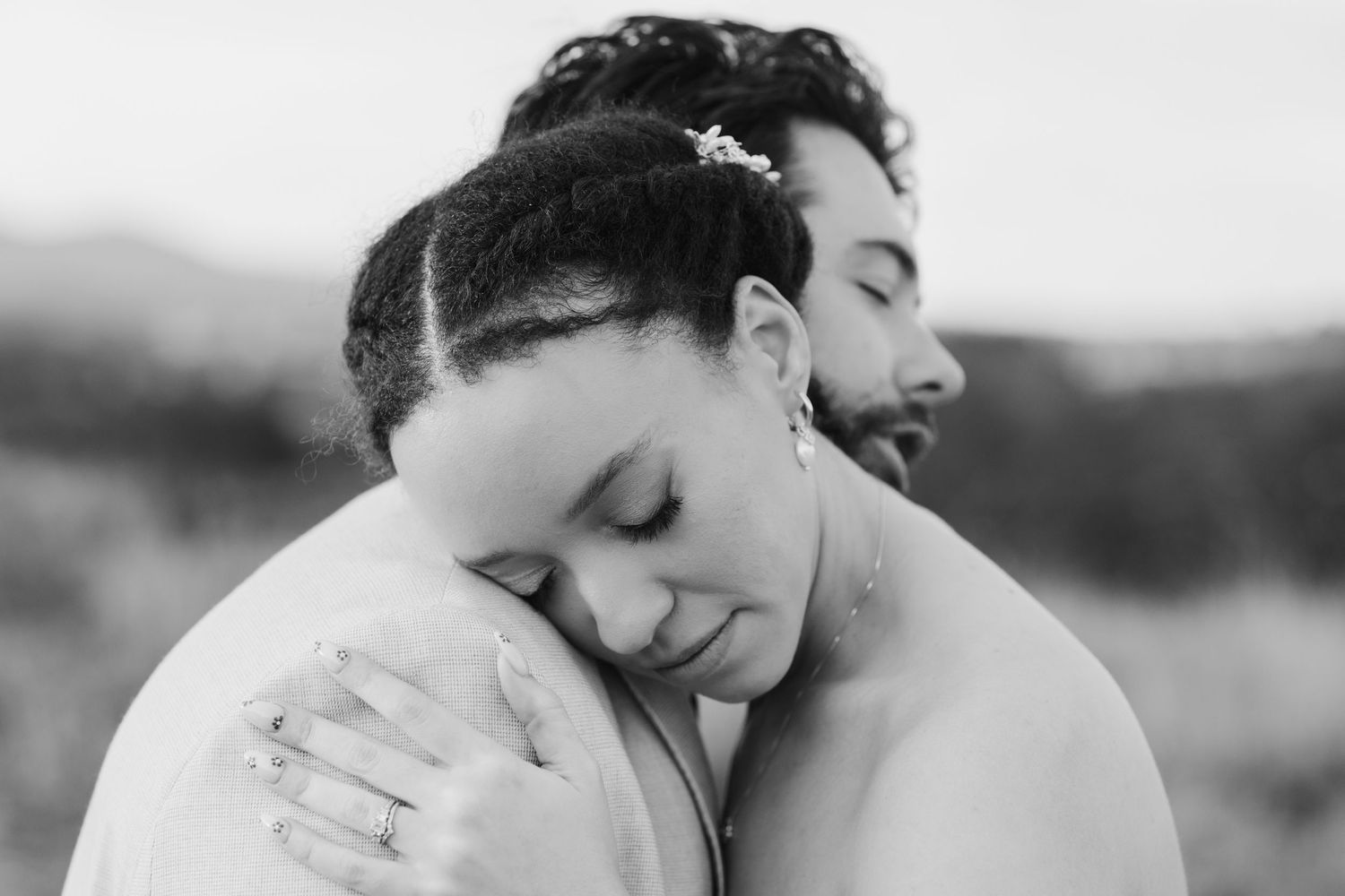 Intimate black and white portrait of newlyweds embracing in a tender moment.
