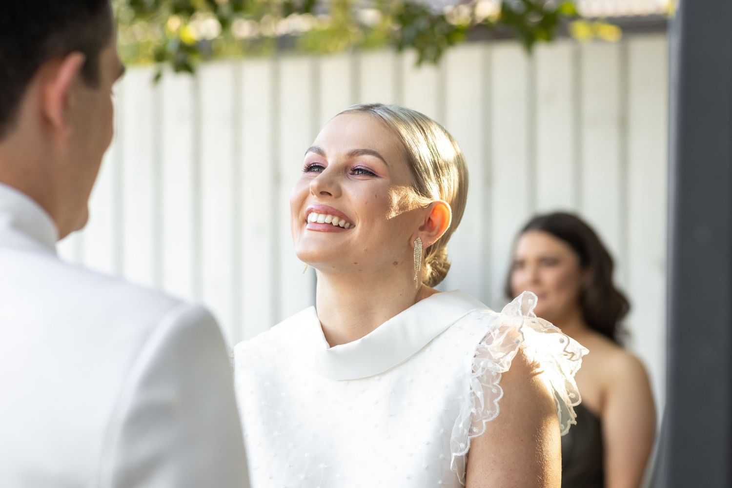 Natural light streams through windows during indoor wedding celebration.