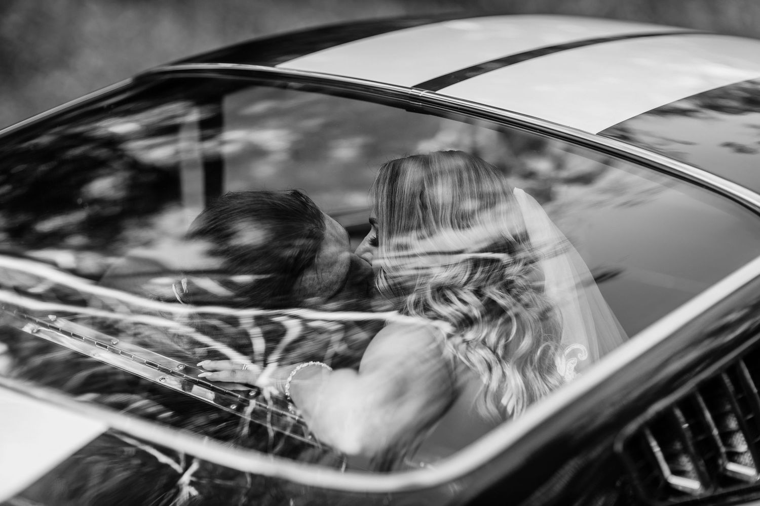 Artistic black and white detail of couple reflected in car window.Gold Coast candid family photographer.