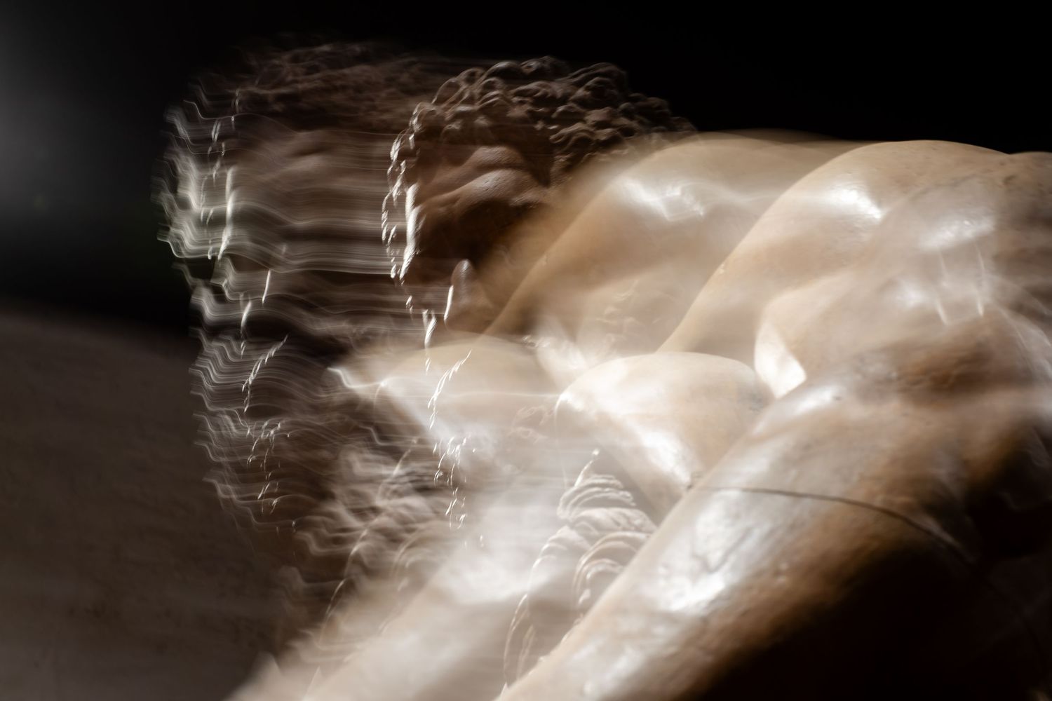 Abstract light trails creating flowing patterns against dark background.
