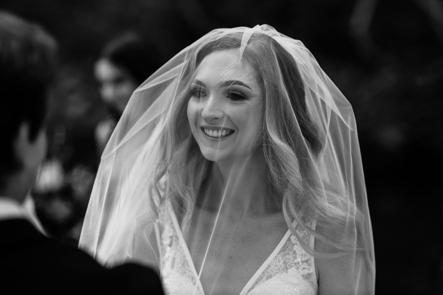 Black and white close-up of a bride wearing a delicate veil during an outdoor ceremony.Currumbin Valley wedding photography Gold Coast