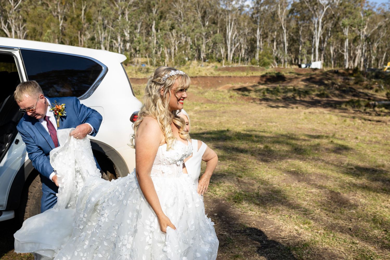 Outdoor wedding ceremony in a rustic mountain setting with white decor and natural scenery.