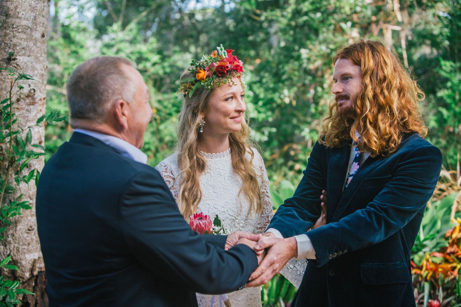 Wedding celebration in a natural outdoor setting with trees and greenery.