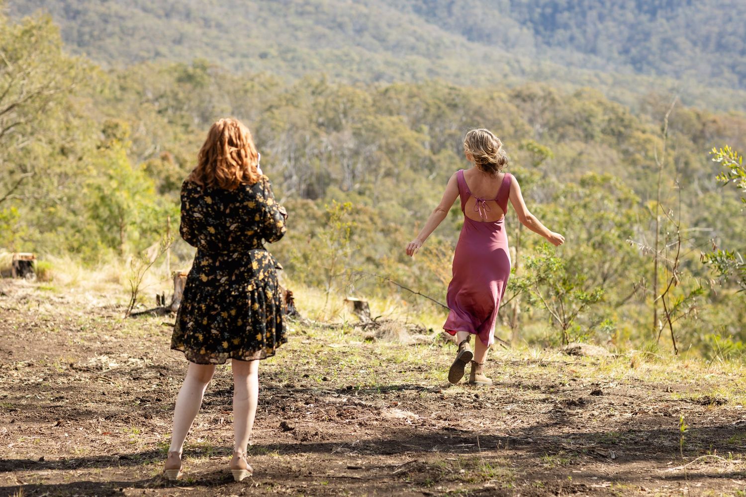 People dancing and celebrating on a grassy hillside during an outdoor event.