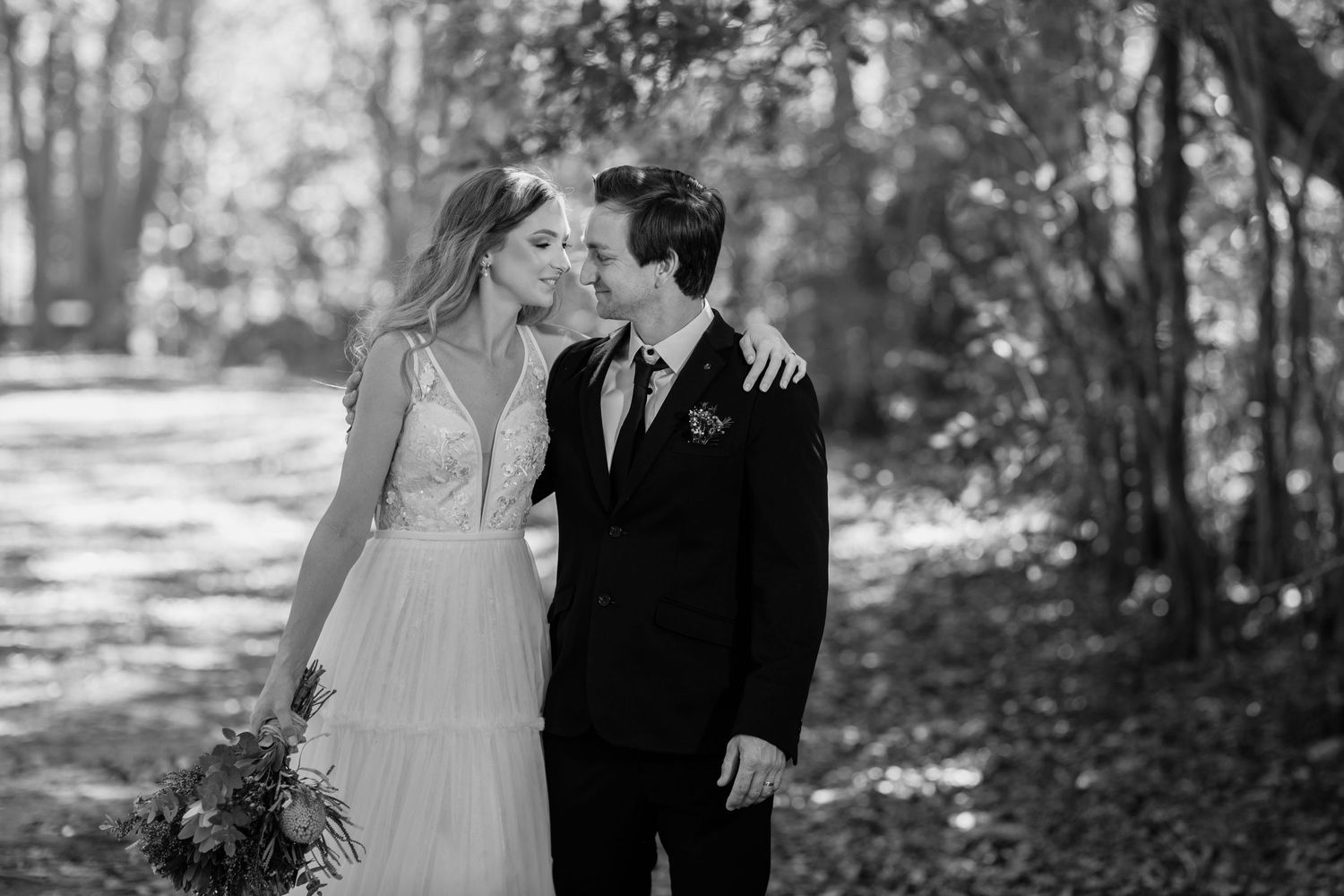 Sun-dappled forest setting frames romantic wedding couple portraits.Currumbin Valley wedding photography Gold Coast