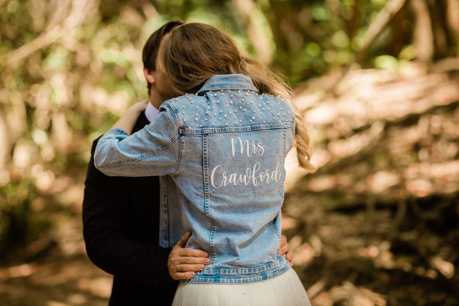 Custom denim jackets with wedding text displayed in a natural outdoor setting.Gold Coast beach wedding photography