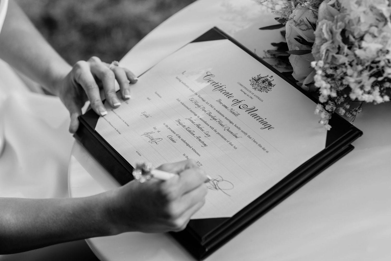Black and white photo of signing marriage certificate during wedding ceremony.Miami Burleigh heads beach wedding