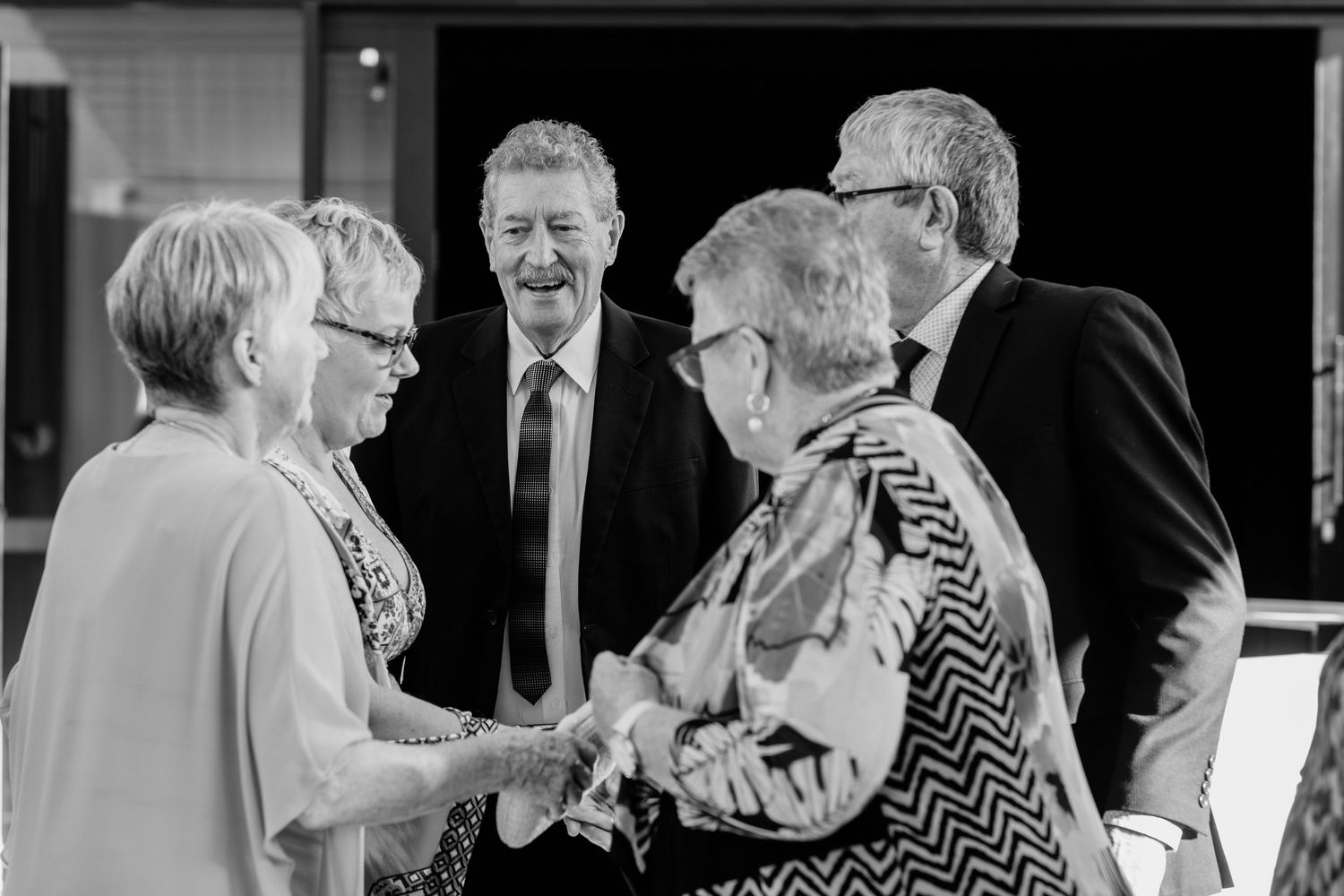 Wedding guests enjoying conversation and laughter at reception.