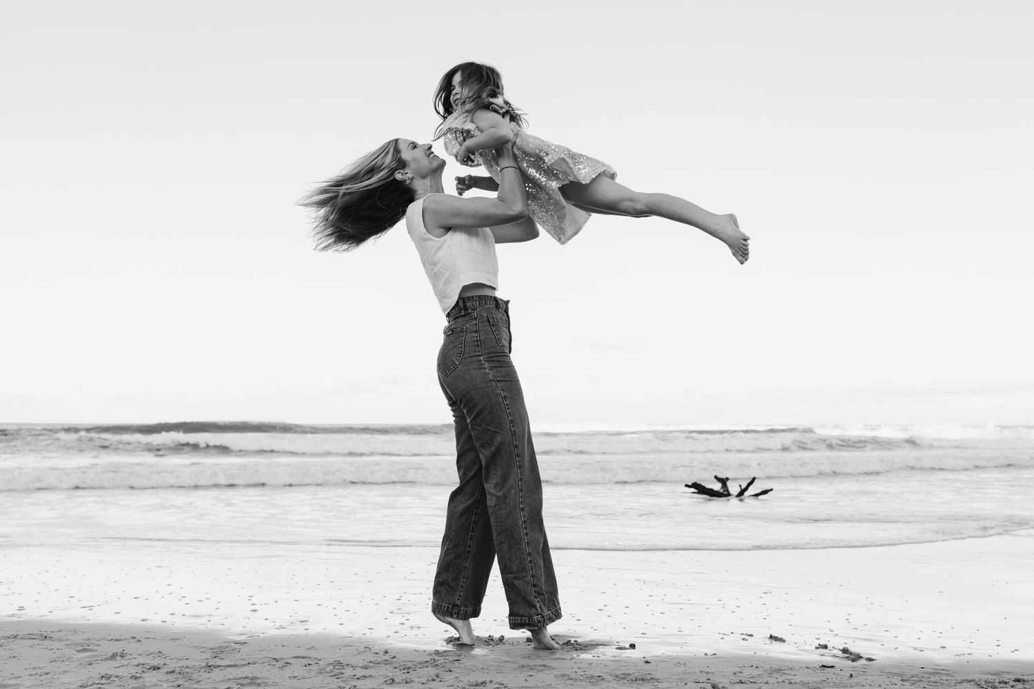 Artistic black and white photos of dance-like poses on beach.Gold Coast candid family photographer. Gold Coast candid family photographer. C