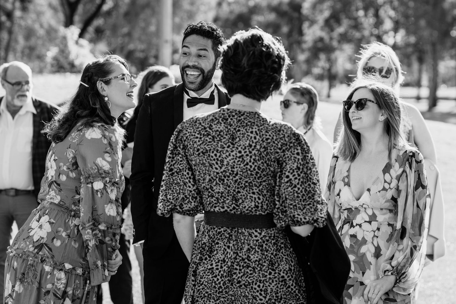 Wedding guests mingling outdoors in floral dresses and formal attire. Surfers Paradise Golf Club wedding.