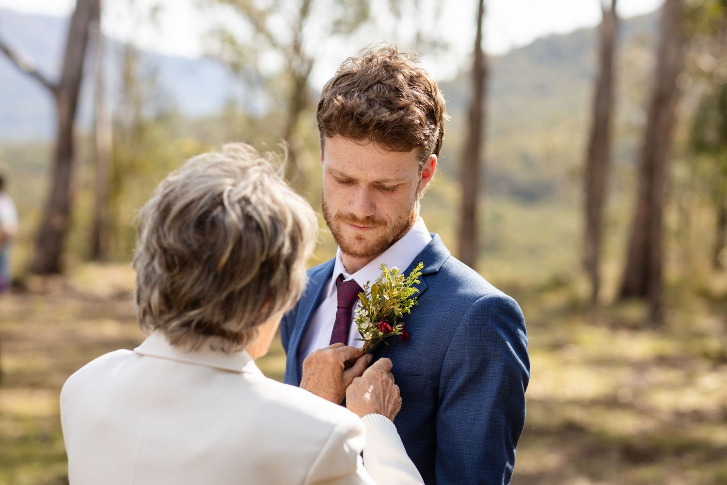 Couple shares intimate moment in natural outdoor setting.