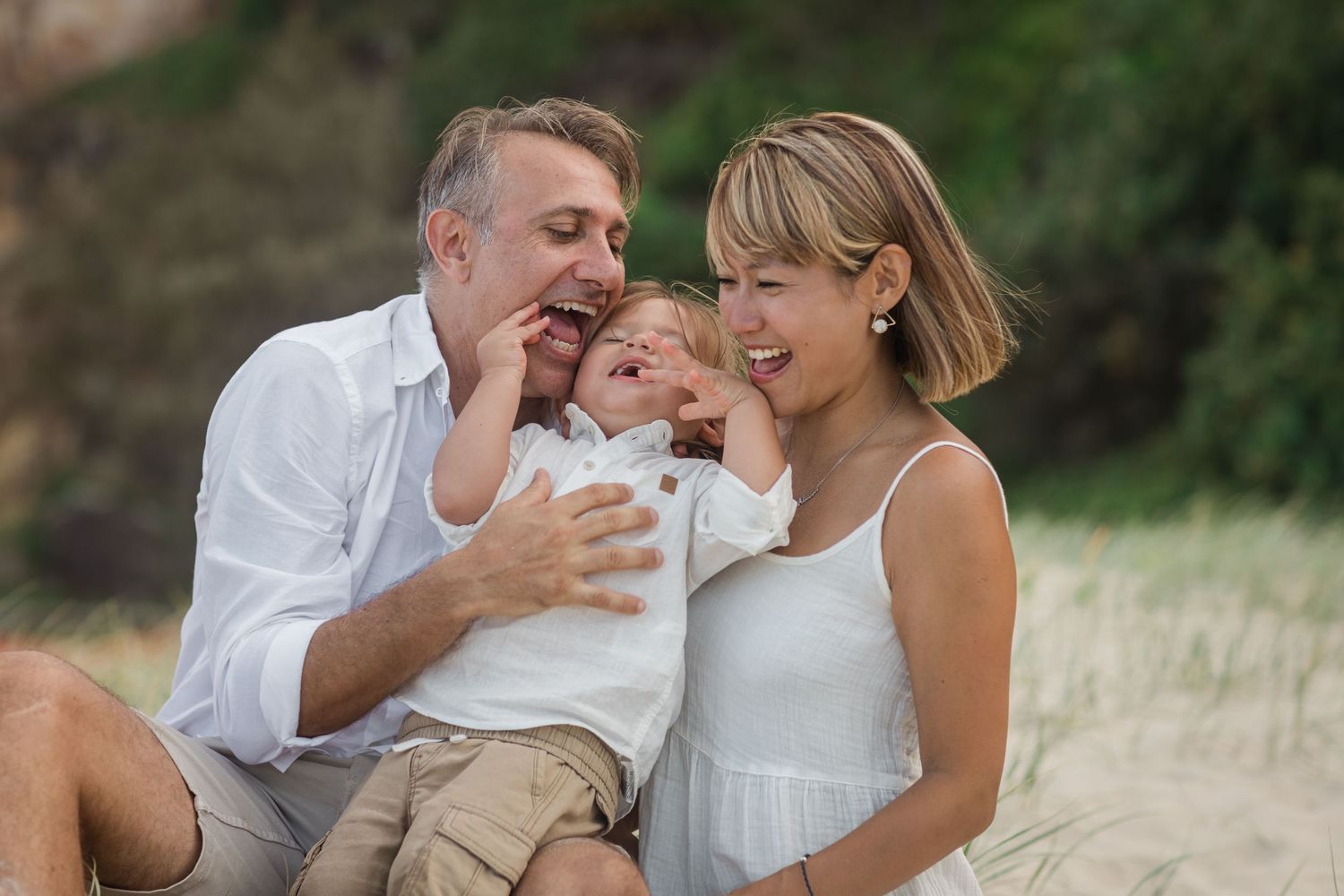Intimate family photoshoot in a grassy field during golden hour.Gold Coast candid family photographer.