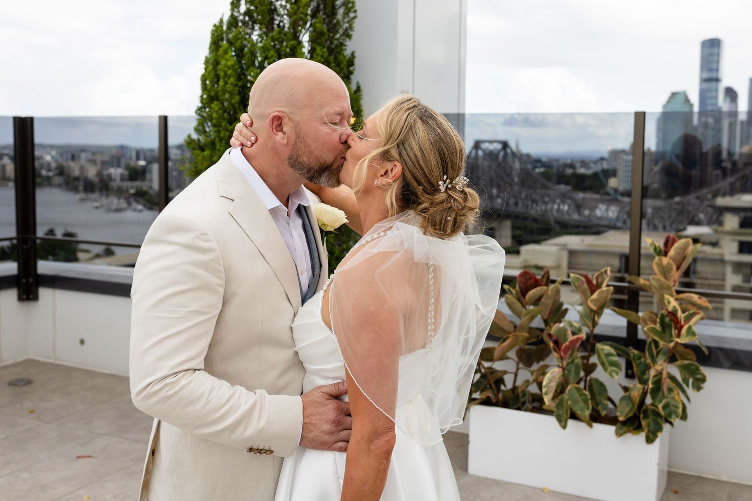 Elegant outdoor wedding celebration with urban backdrop and natural decor.