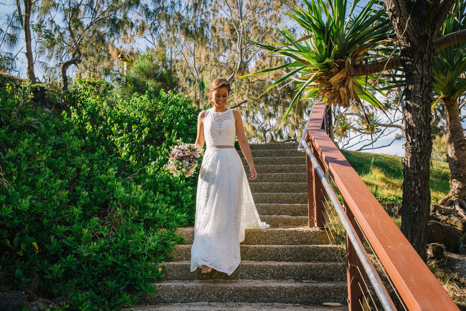 Stone steps with palm trees leading to a tropical wedding ceremony location.