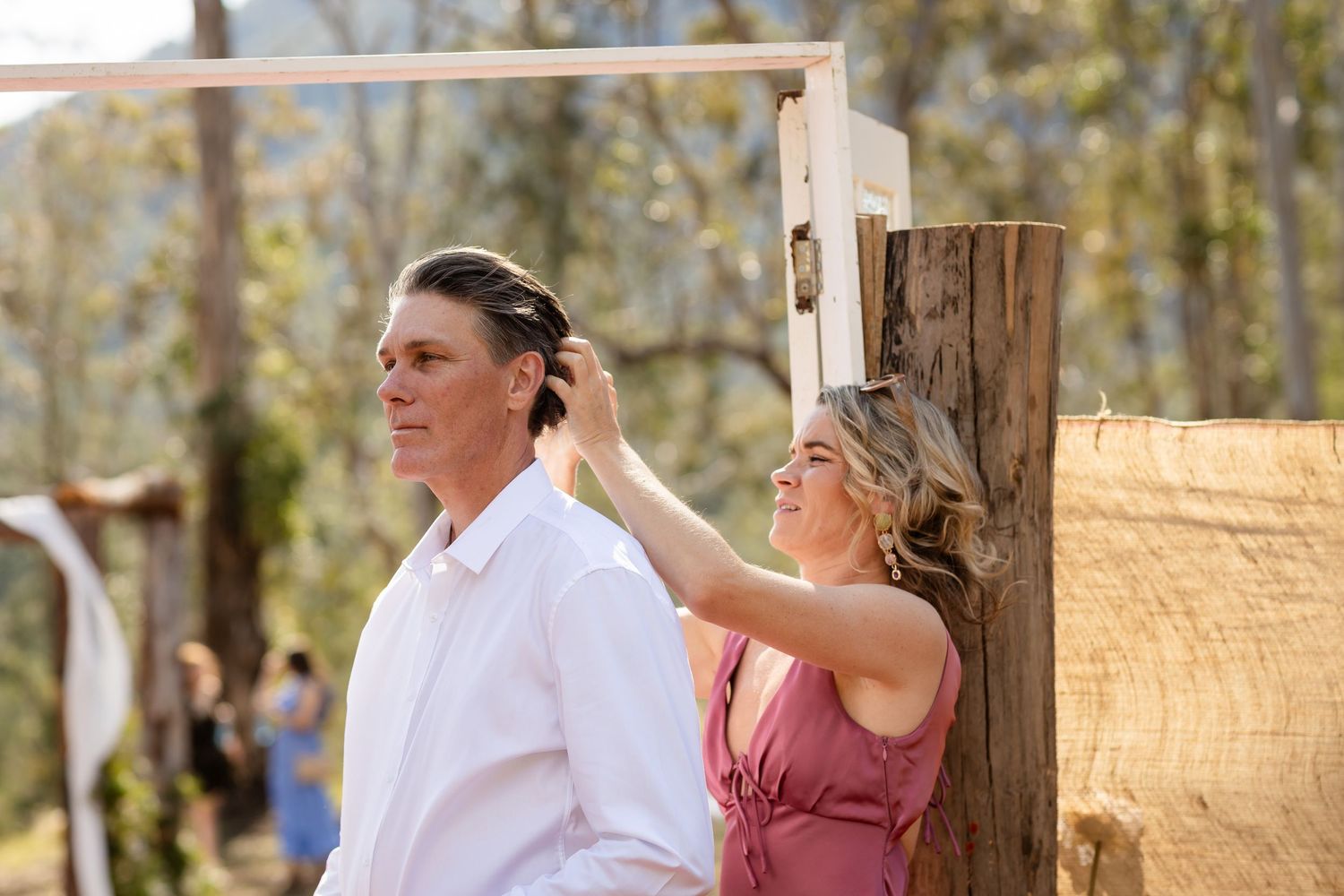 Wedding party dancing and celebrating outdoors with mountains in the background.