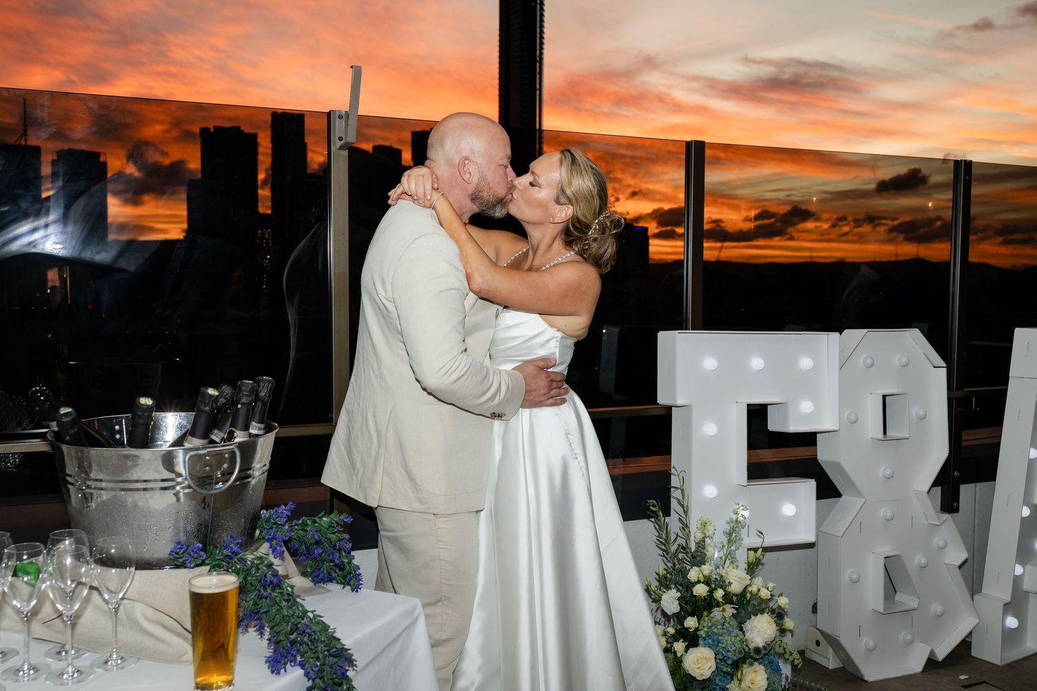 Sunset wedding reception with dramatic orange sky and silhouetted decorations. Brisbane wedding venue