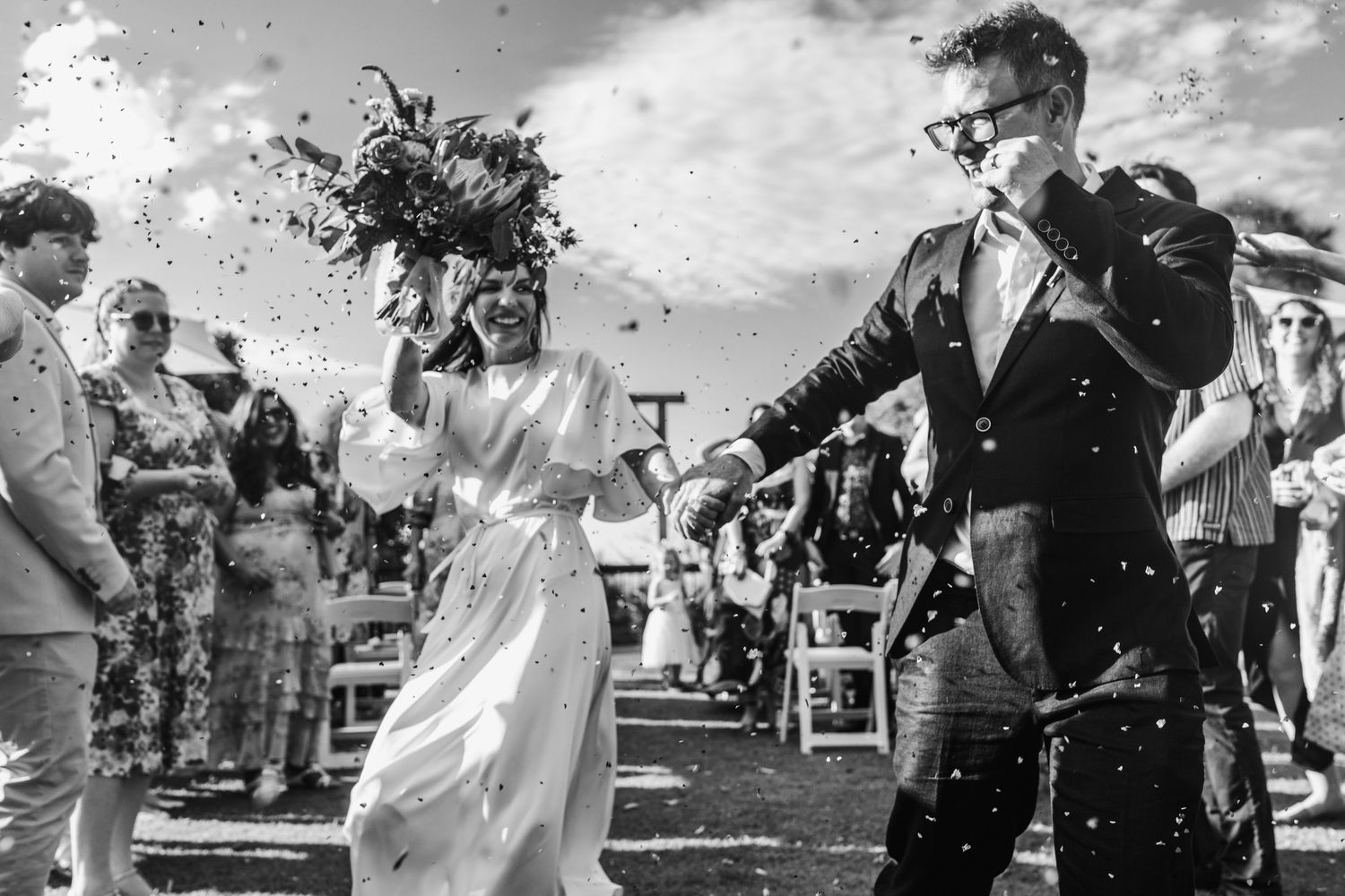 Black and white collage of wedding celebration moments showing dancing, laughter and joy at an outdoor reception.