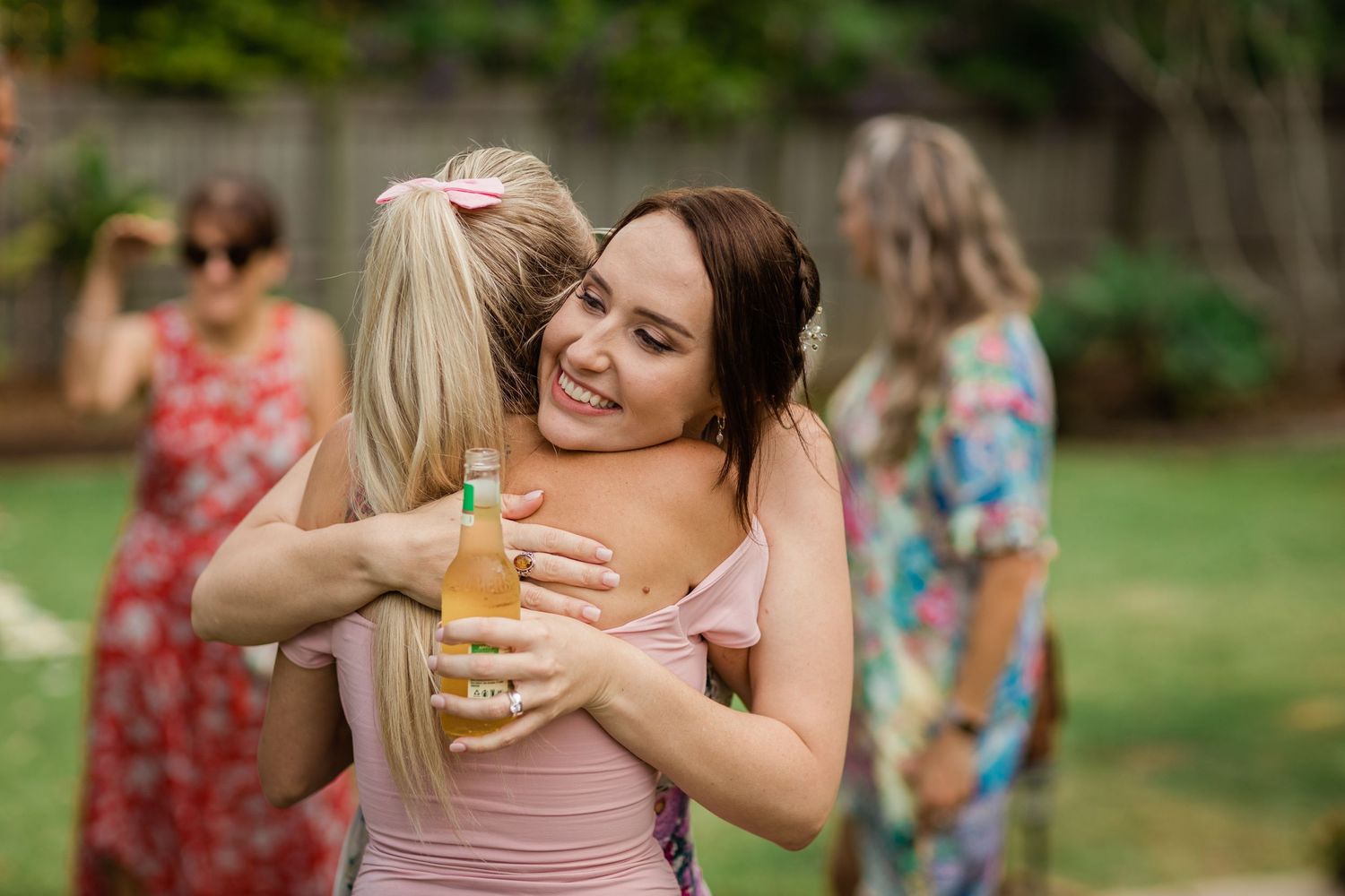 Guests celebrate at an outdoor garden party with drinks and hugs.Gold Coast elopement photographer