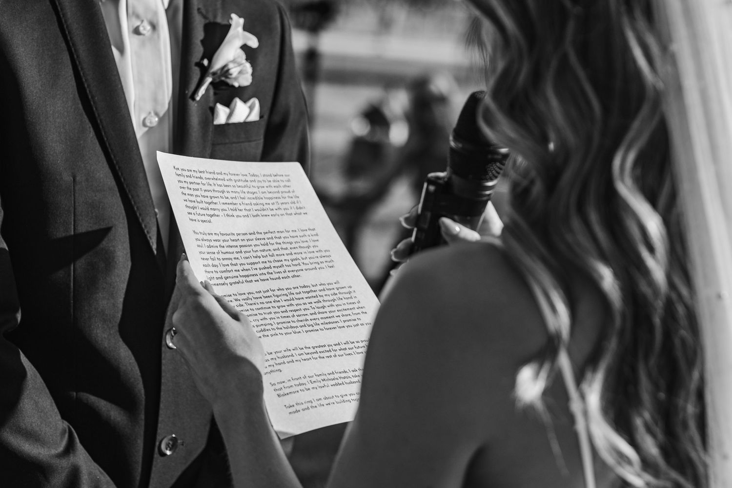 Black and white shot of wedding ceremony vow reading with papers in hand.beach wedding currumbin surf club wedding