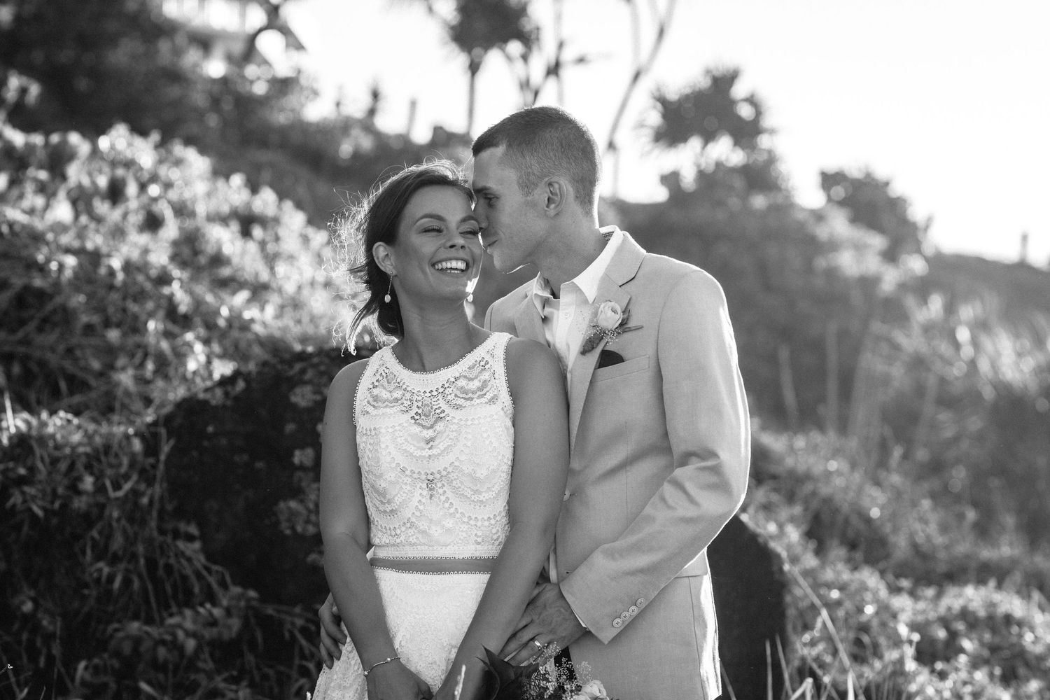 A joyful wedding couple sharing a tender moment outdoors in black and white.Gold Coast beach wedding photography. Froggies beach