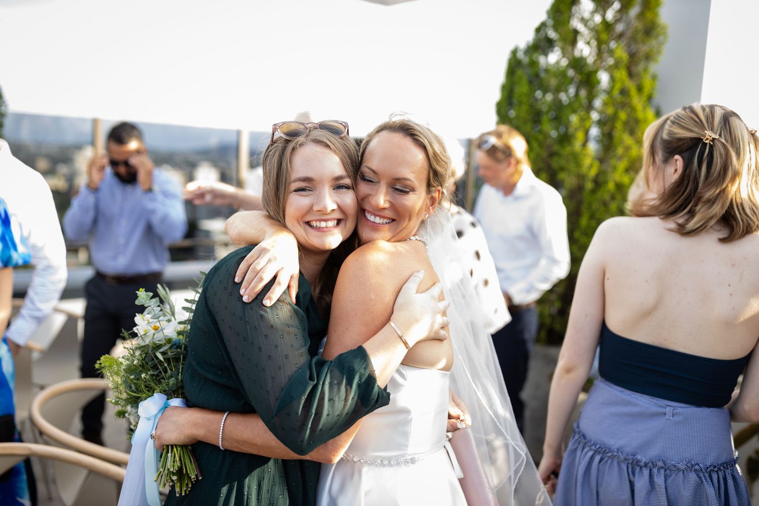 Wedding guests mingling and embracing during an outdoor celebration.wedding ceremony at iris rooftop hotel in brisbane.