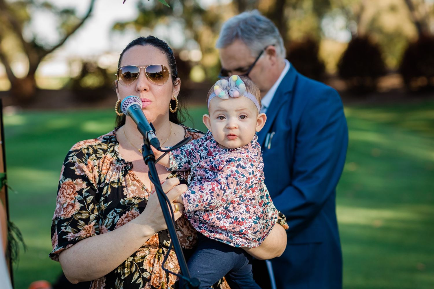Wedding guests watching the ceremony while holding young children.