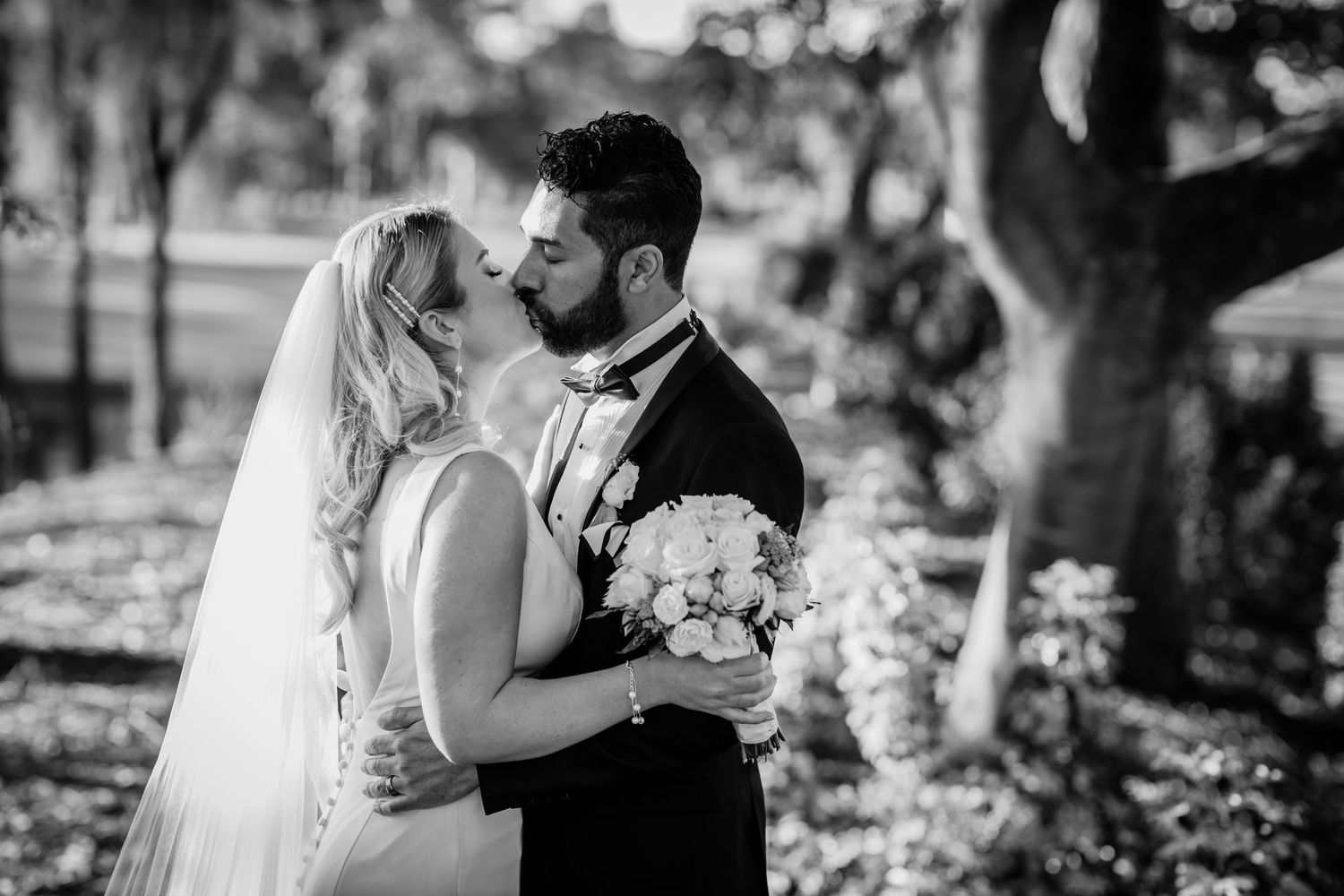A romantic black and white wedding photo captured in a wooded outdoor setting. Surfers Paradise Golf Club wedding.