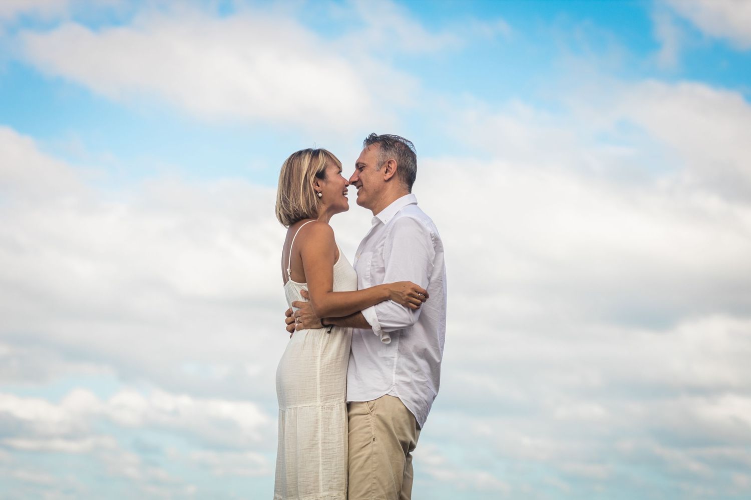 Romantic beach photoshoot with blue skies and fluffy white clouds.Gold Coast candid family photographer.