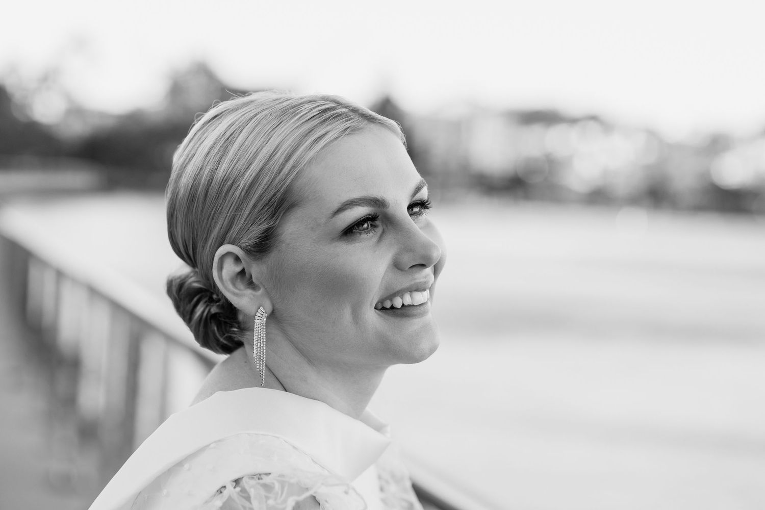 Side profile portraits of bride with elegant updo hairstyle against bright background.