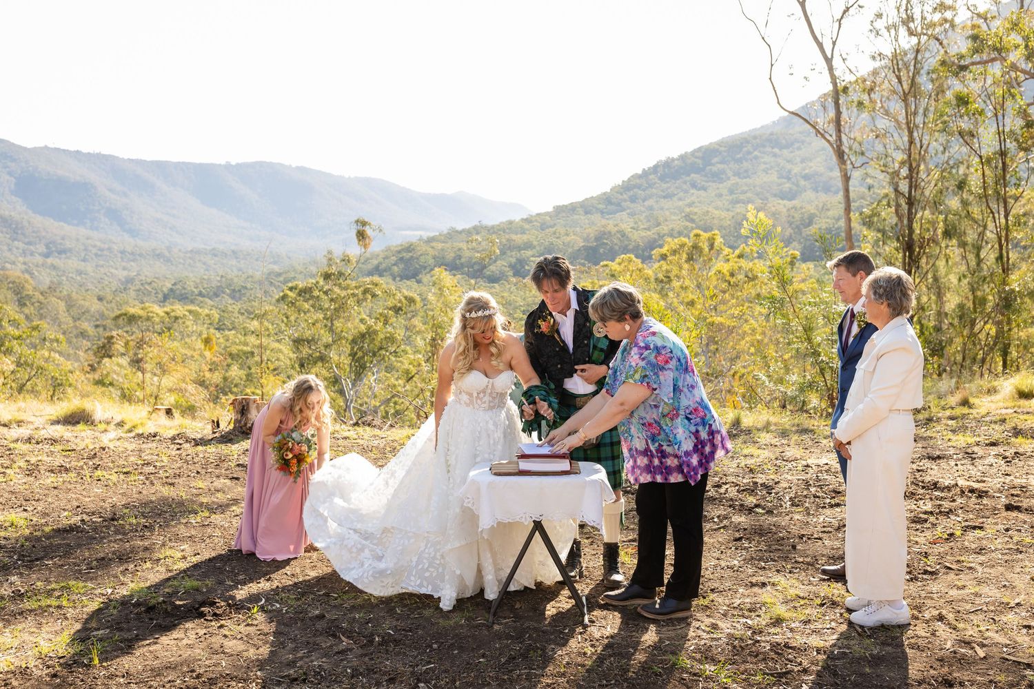 Outdoor wedding ceremony overlooking scenic mountain vista with wedding party in formal attire.Gold Coast wedding photographer