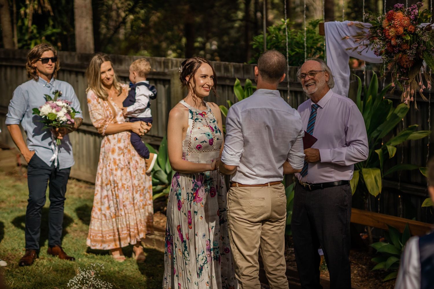 Casual outdoor wedding gathering with guests mingling among tropical plants.Gold Coast beach wedding photography