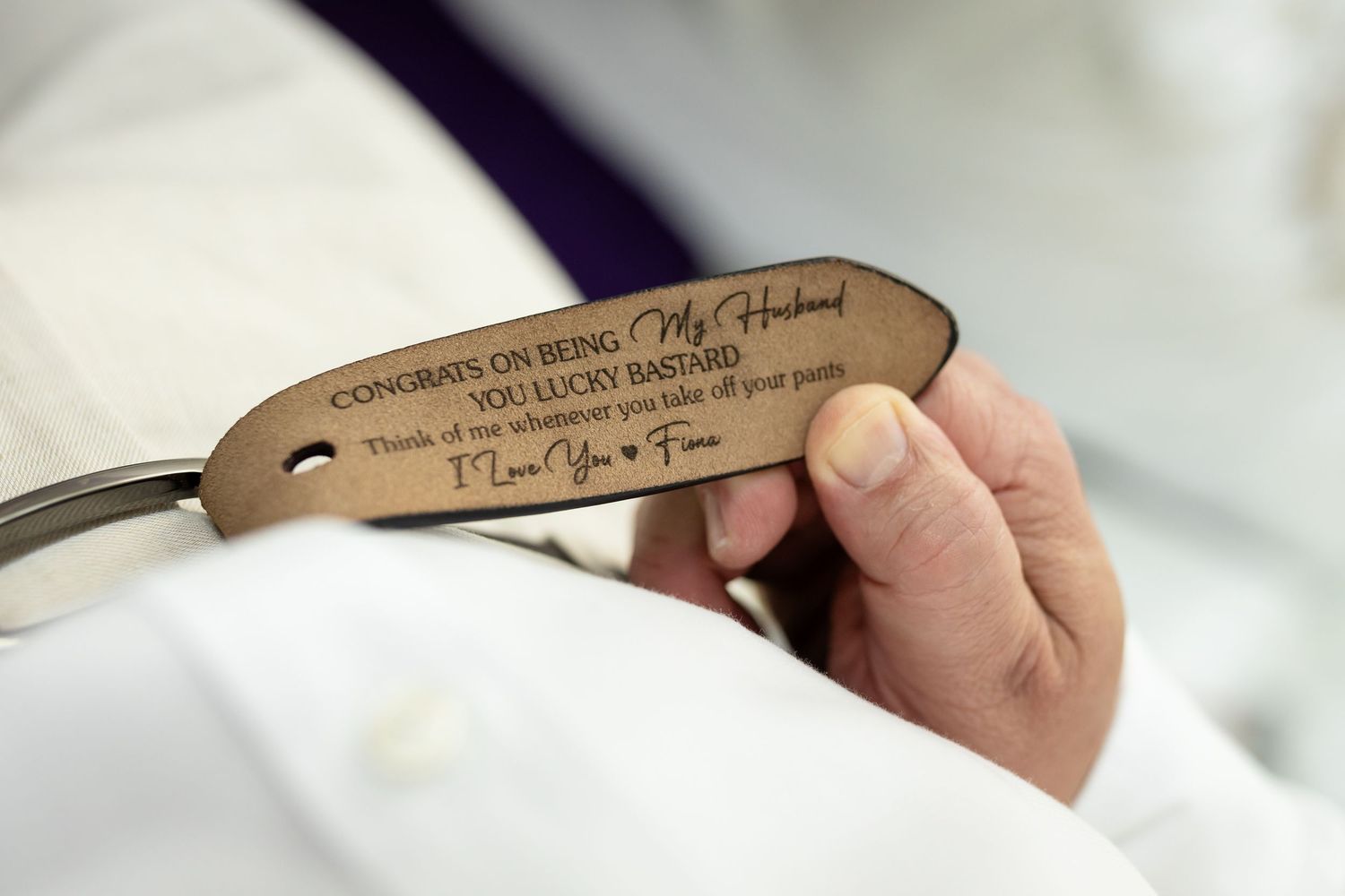 Close-up of engraved wooden hanger with personalized wedding message.