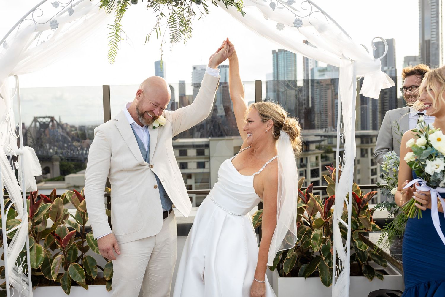 Elegant rooftop wedding ceremony setup with white decor and tropical plants.wedding ceremony at iris rooftop hotel in brisbane.