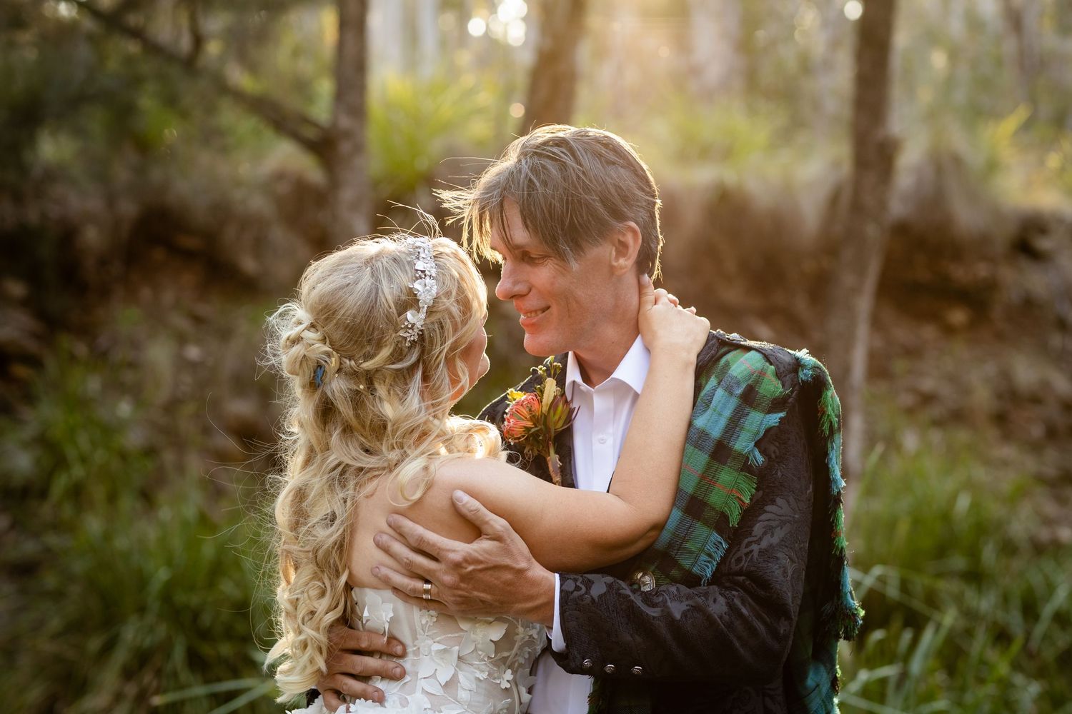 Tender embrace captured in natural bushland setting with Scottish wedding attire.Gold Coast wedding photographer